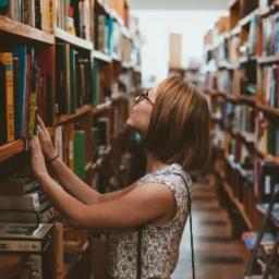 A woman searches the bookshelves